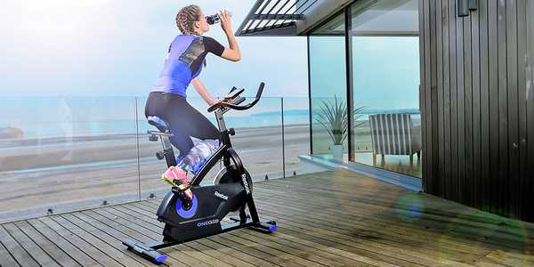 A woman using an exercise bike at home.